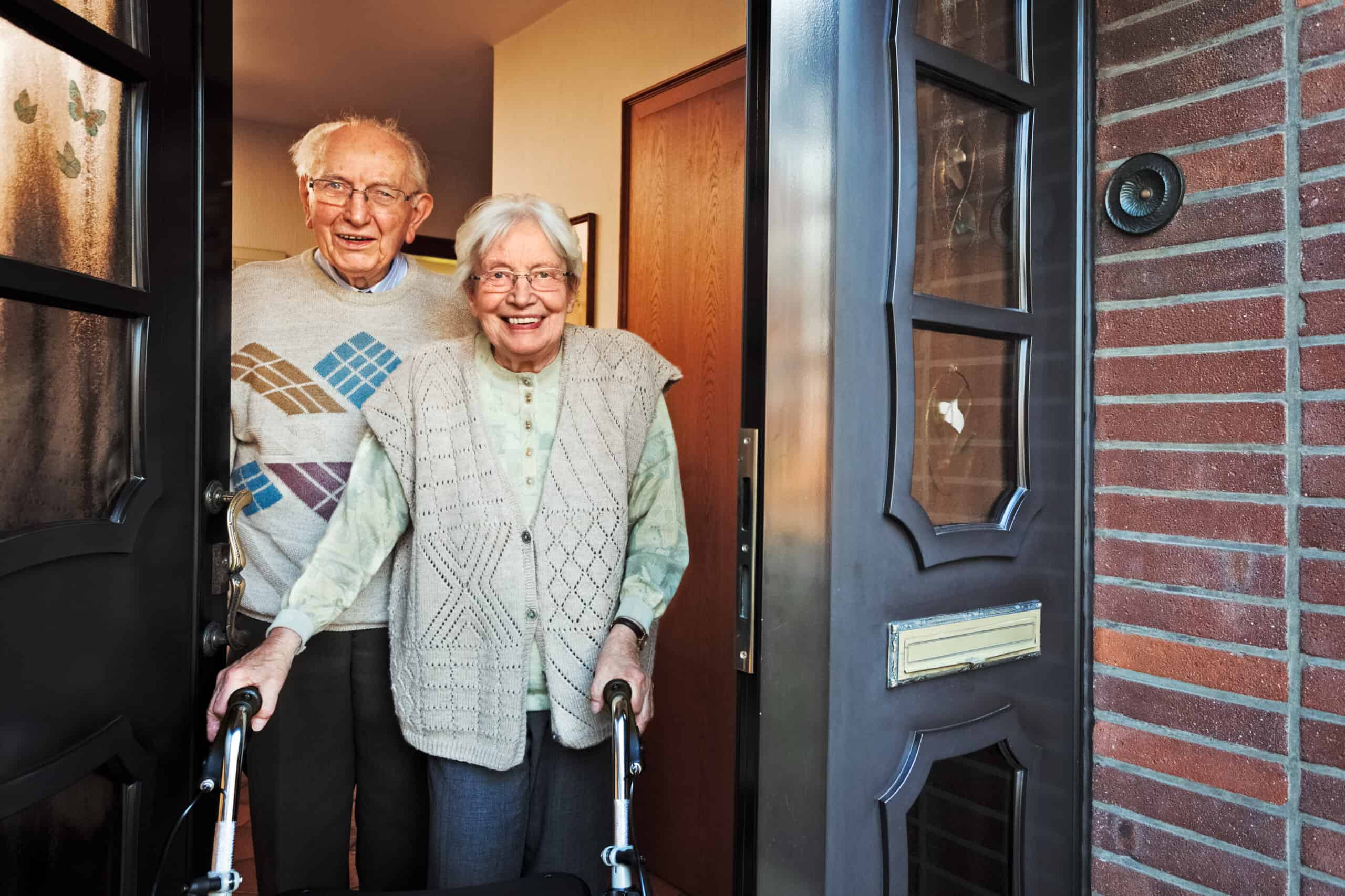 Happy,Elderly,Couple,Opening,The,Front,Door