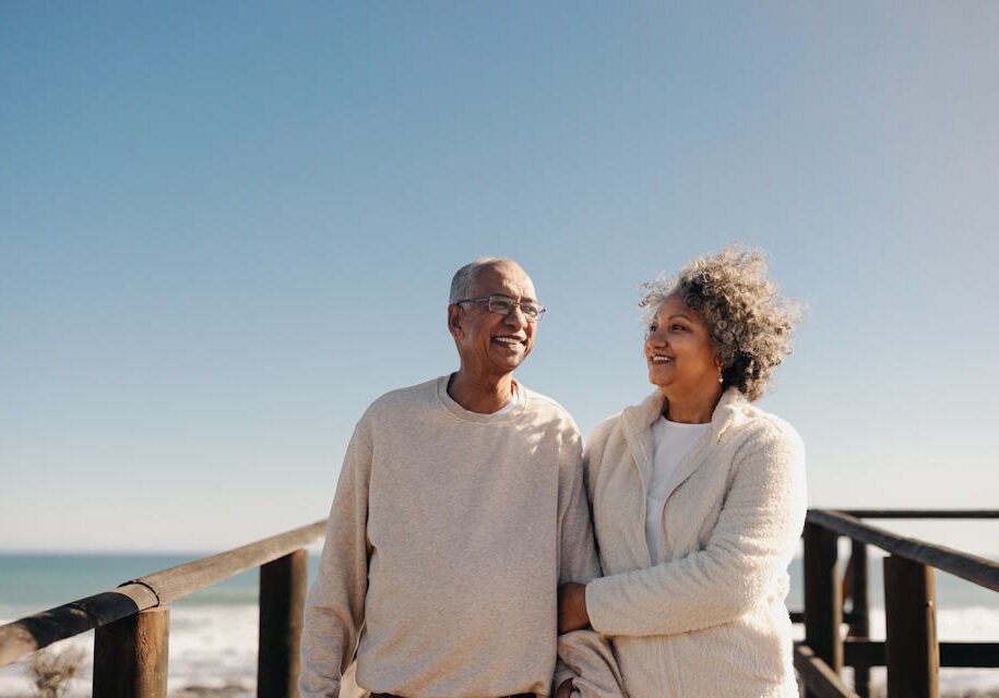 Mature,Couple,Smiling,Happily,While,Taking,A,Walk,Along,A